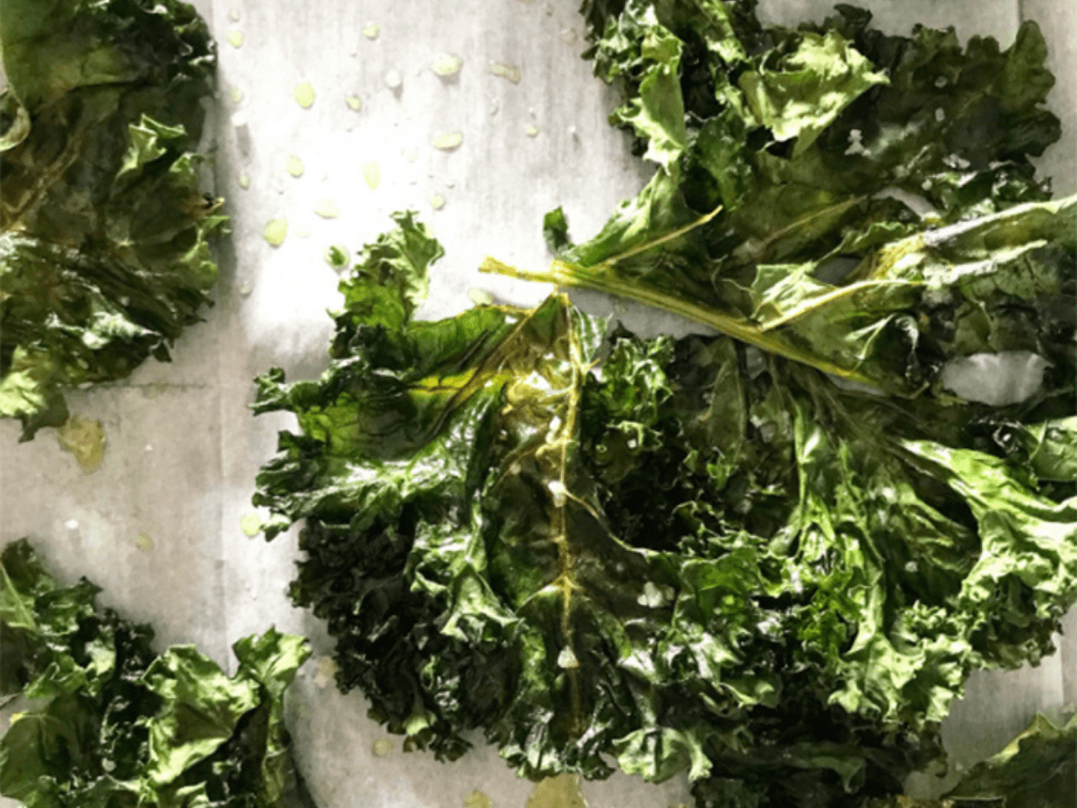 Baked pieces of kale with drizzle of oil and salt